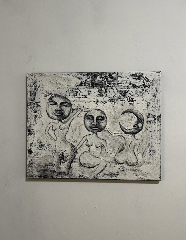 Sisters — three figures with moon faces in black and white